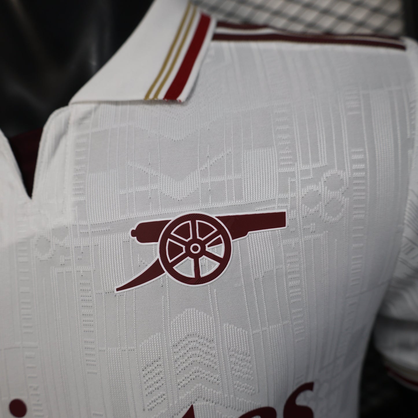 2025/26 Arsenal Away Player Version Jersey - White Body All-Over Tonal Emirates Stadium Architectural Line Emboss Pattern Deep Maroon Polo Collar Multi-Stripe Gold Red White Trim -Arsenal Cannon Crest - Emirates Fly Better