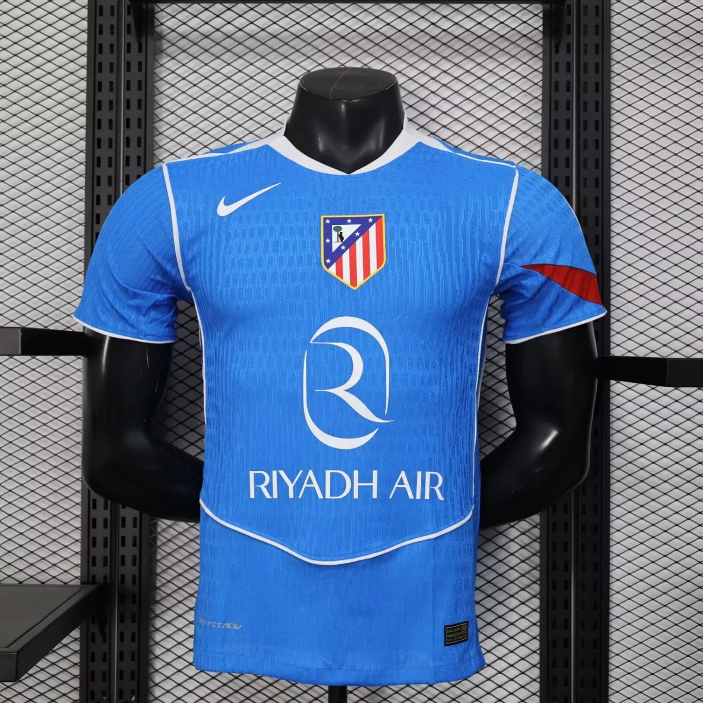 2025/26 Atlético Madrid Away Player Version Jersey - Sky Blue Body All-Over Subtle Diamond Tonal Texture White V-Neck Collar White Trim Red Diagonal Slash Left Sleeve Cuff Accent - White Swoosh - Atlético Madrid Official Shield Crest - Riyadh Air - Men's