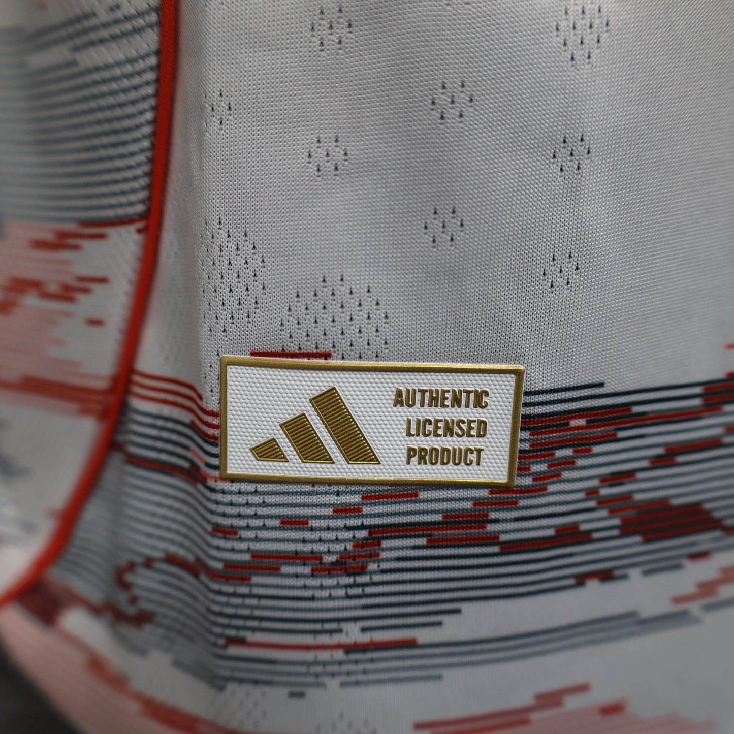2025/26 Bayern Munich Away Player Version Jersey - White Body Red & Grey Horizontal Brushstroke Graphic - Orange Sleeve Cuffs - Black Adidas Three Stripes - FC Bayern Crest - Deutsche Telekom T Logo