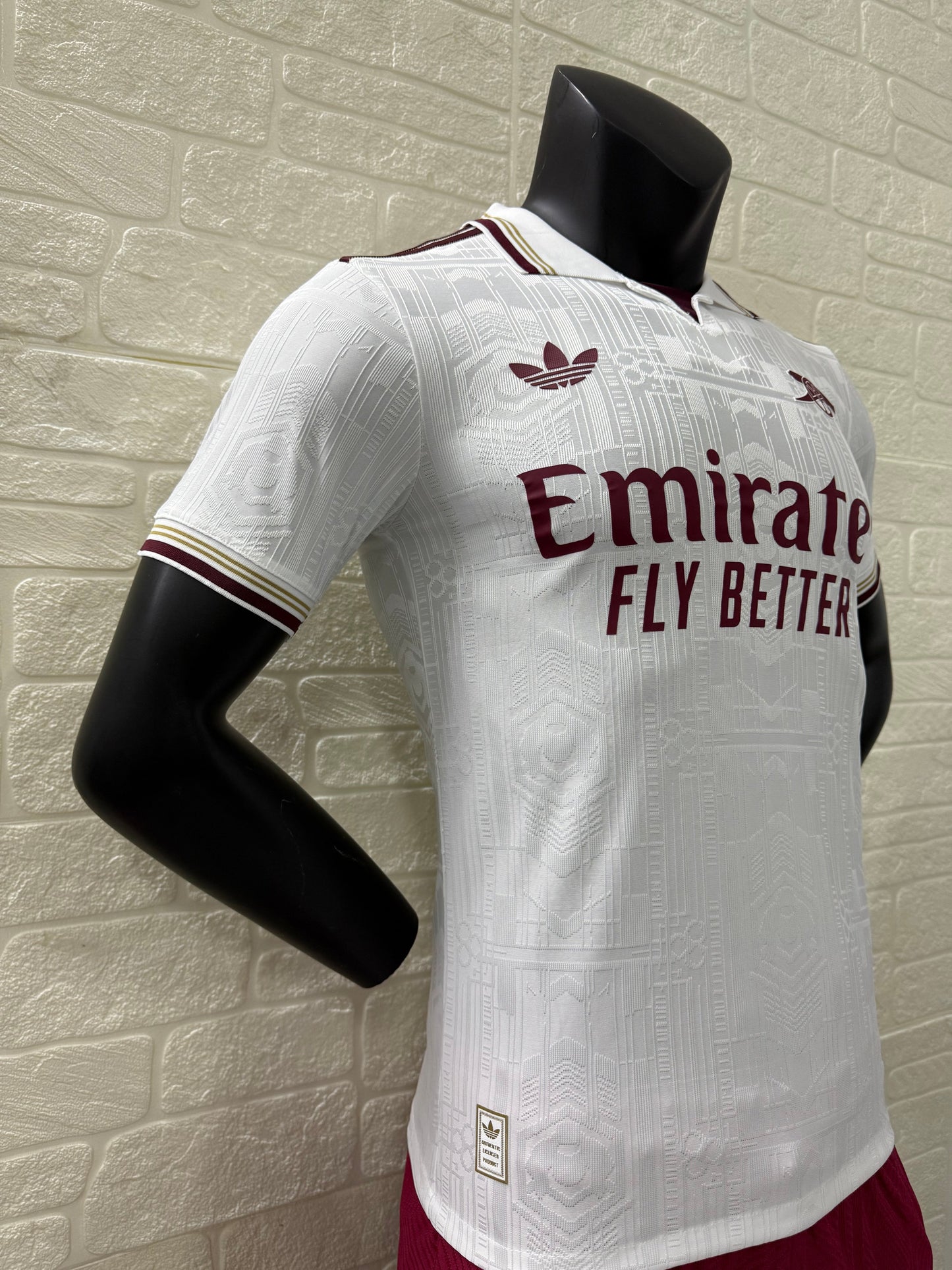 2025/26 Arsenal Third Player Version Jersey - White Body All-Over Subtle Tonal Graphic Texture Deep Maroon Polo Collar Gold Cream Stripe Trim Deep Maroon Sleeve Cuff Trim - Originals Trefoil - Arsenal Cannon Crest - Emirates Fly Better