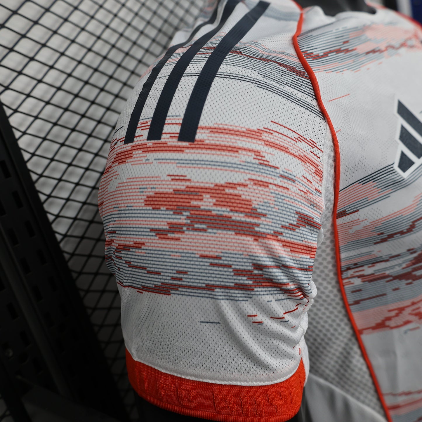 2025/26 Bayern Munich Away Player Version Jersey - White Body Red & Grey Horizontal Brushstroke Graphic - Orange Sleeve Cuffs - Black Adidas Three Stripes - FC Bayern Crest - Deutsche Telekom T Logo