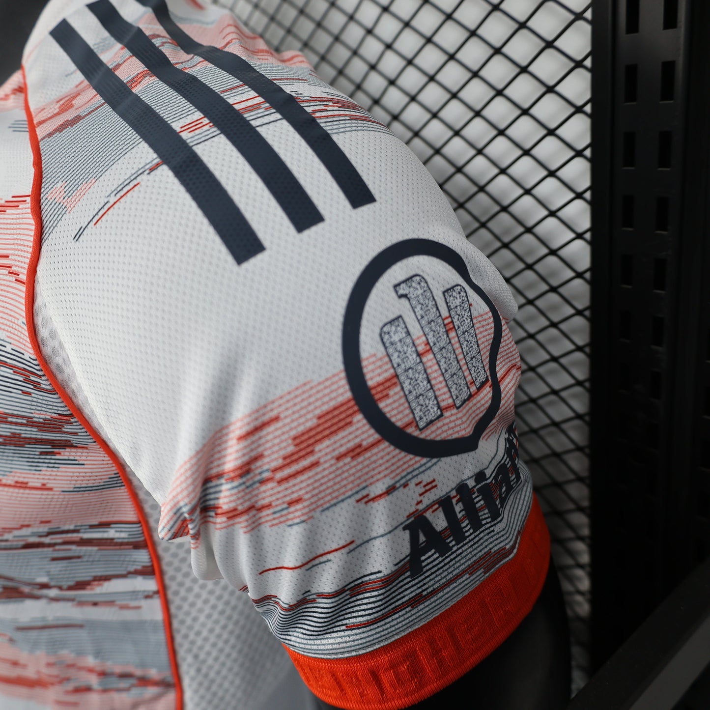 2025/26 Bayern Munich Away Player Version Jersey - White Body Red & Grey Horizontal Brushstroke Graphic - Orange Sleeve Cuffs - Black Adidas Three Stripes - FC Bayern Crest - Deutsche Telekom T Logo