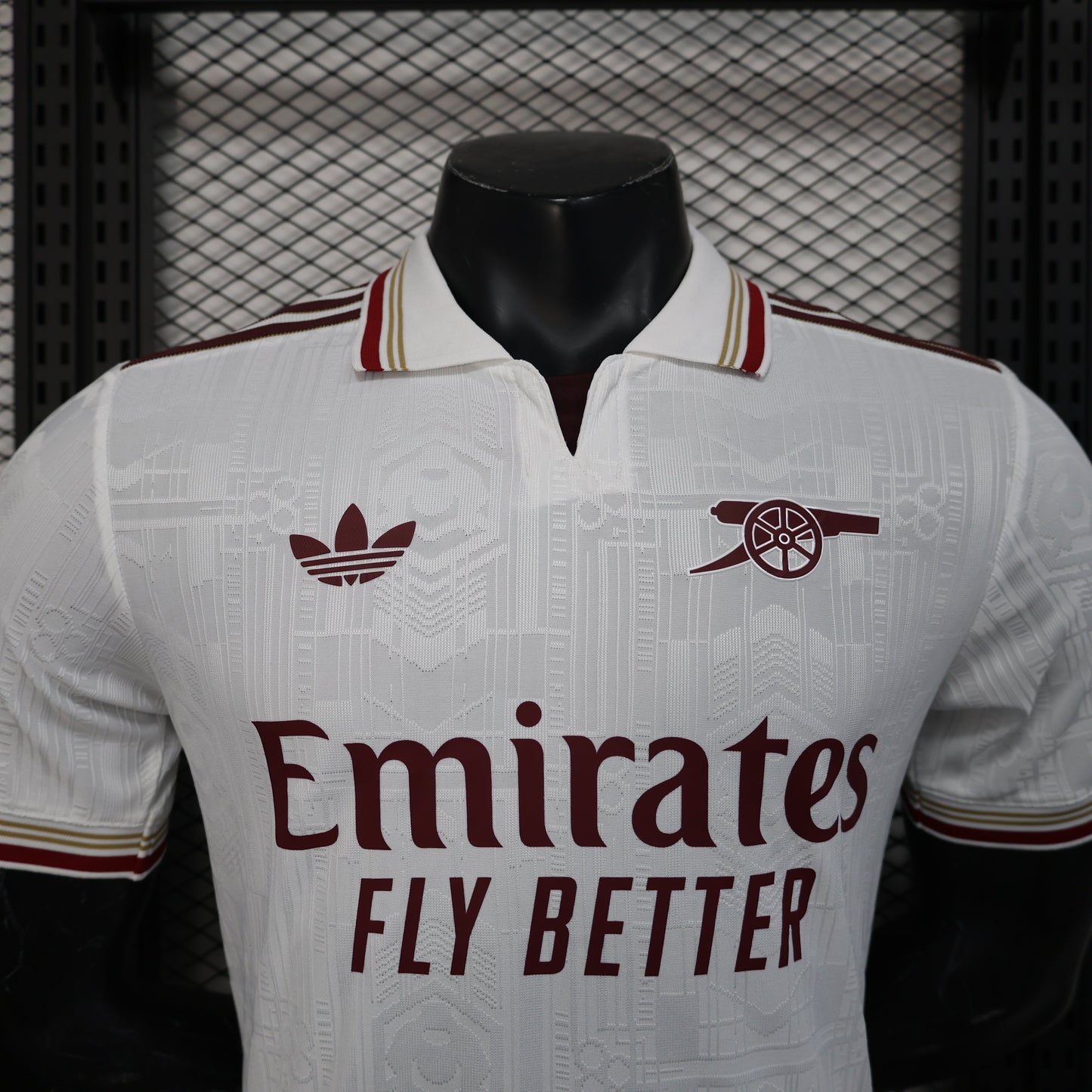 2025/26 Arsenal Away Player Version Jersey - White Body All-Over Tonal Emirates Stadium Architectural Line Emboss Pattern Deep Maroon Polo Collar Multi-Stripe Gold Red White Trim -Arsenal Cannon Crest - Emirates Fly Better
